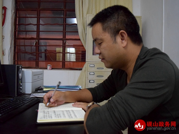 一名干部职工在认真记《工作日志》