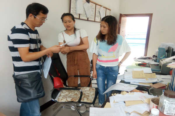 图为工作人员到八寨镇财政所查阅民生资金原始凭证
