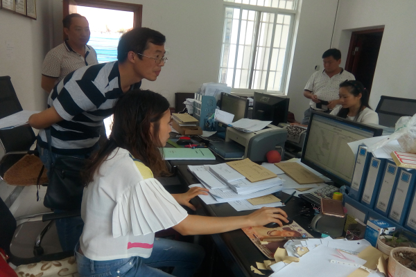 图为工作人员在八寨镇财政所查看民生资金账目